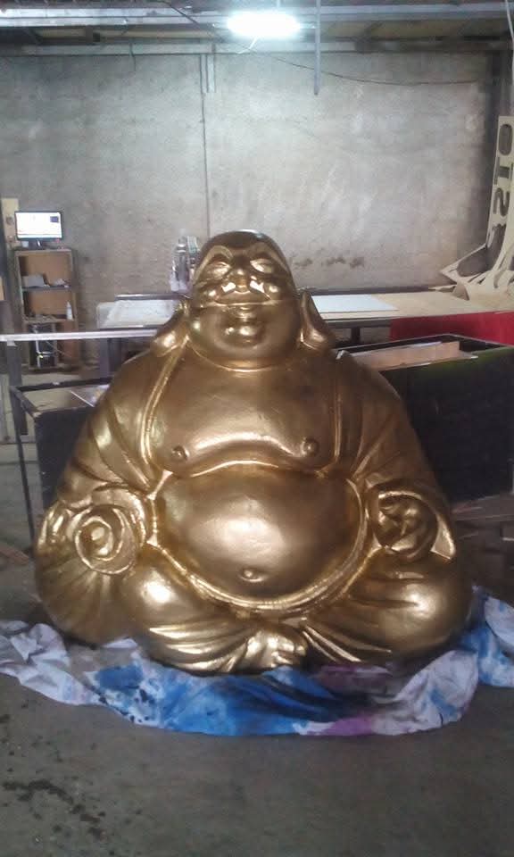 Escultura dourada de Buda finalizada dentro do ateliê
